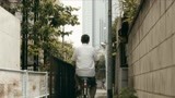 小林薰骑着自行车在日本的街头穿梭